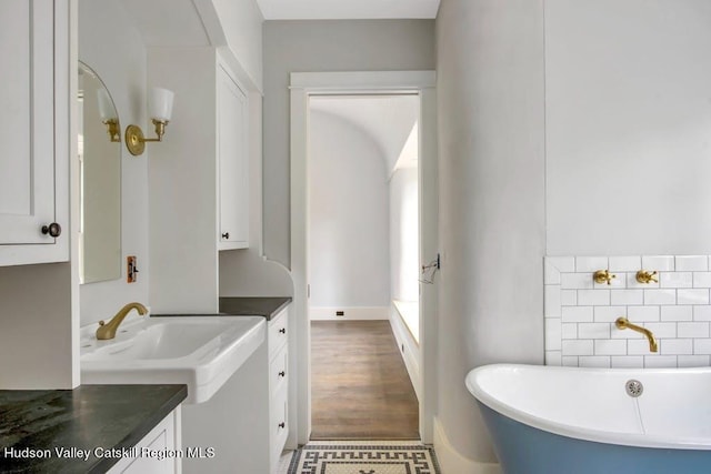 bathroom featuring hardwood / wood-style floors, a bathtub, and vanity