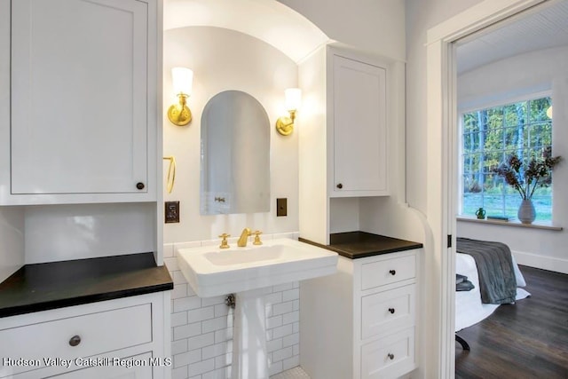 ensuite bathroom with baseboards, wood finished floors, and ensuite bathroom