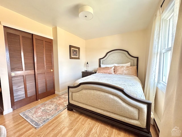 bedroom featuring wood finished floors, a closet, and baseboards