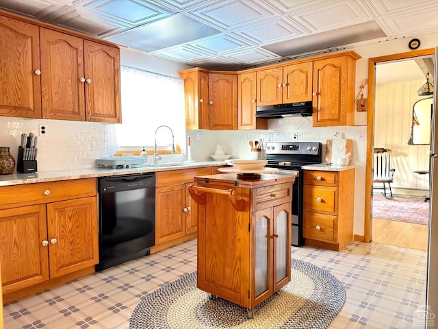 kitchen featuring black dishwasher, stainless steel range with electric cooktop, under cabinet range hood, a sink, and brown cabinets