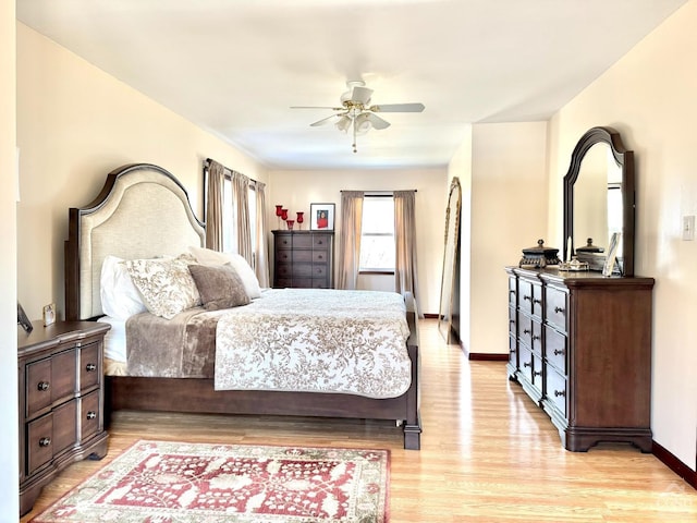bedroom with light wood-style floors, baseboards, and a ceiling fan