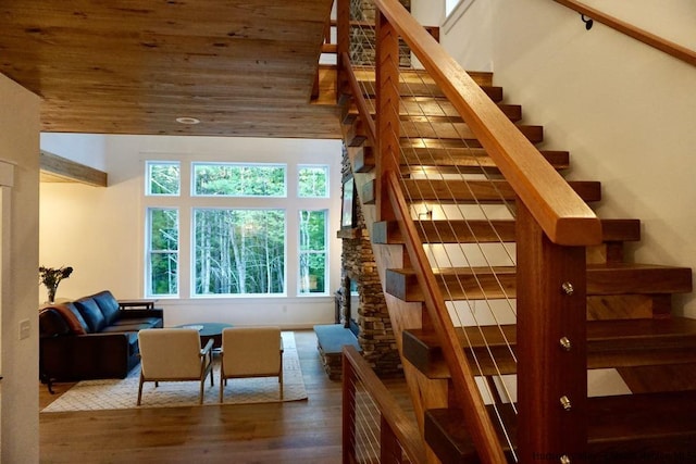 staircase featuring wood ceiling and wood finished floors