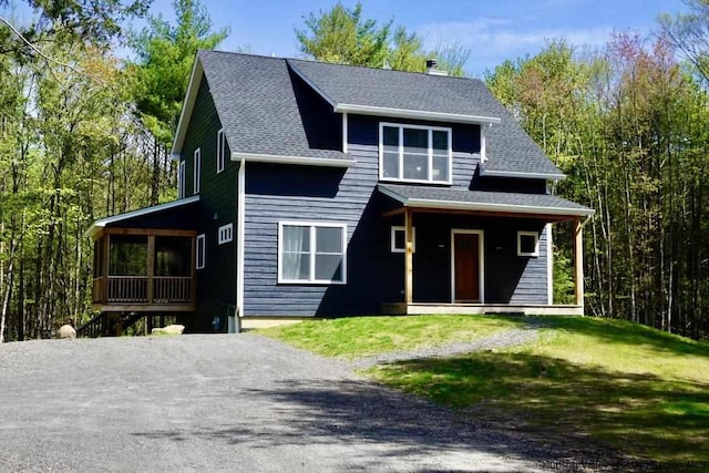 view of front of house featuring a porch, a front lawn, and roof with shingles