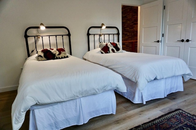 bedroom with baseboards and wood finished floors