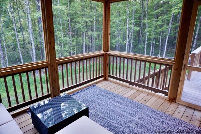wooden terrace with a wooded view