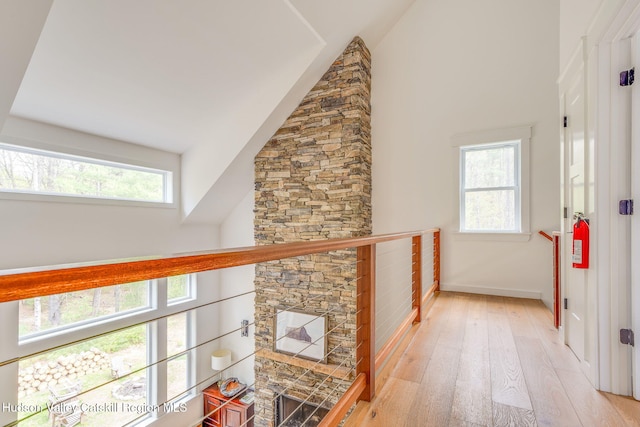51 Houtman Rd, Saugerties, NY 12477 - hall with baseboards, light wood-type flooring, high vaulted ceiling, and an upstairs landing