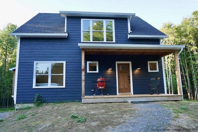 view of front of home with a porch and a shingled roof