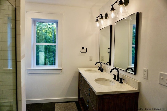 full bathroom featuring double vanity, a sink, baseboards, and tile patterned floors