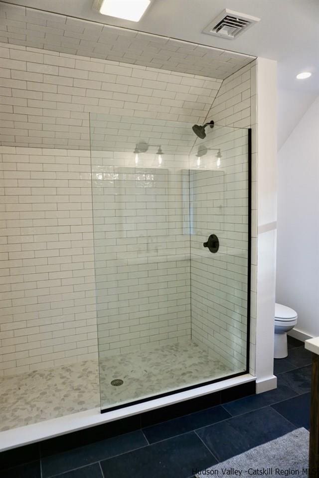 full bathroom featuring visible vents, tile patterned flooring, toilet, and a shower stall