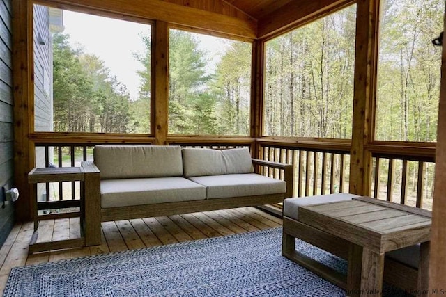 sunroom / solarium with a wooded view and an outdoor hangout area