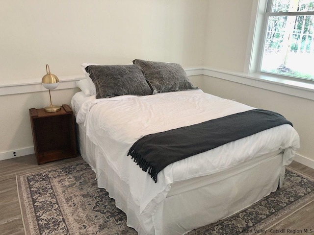 bedroom featuring baseboards and wood finished floors