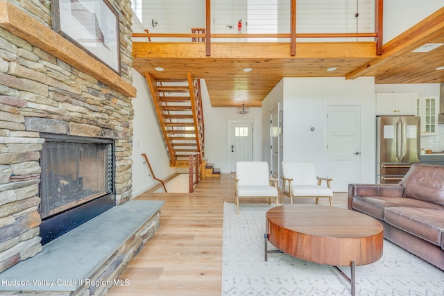 51 Houtman Rd, Saugerties, NY 12477 - living room with baseboards, a stone fireplace, stairs, and light wood-style flooring