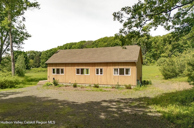129 Krum Rd, Kerhonkson, NY 12446 - view of property exterior with roof with shingles, driveway, and a view of trees