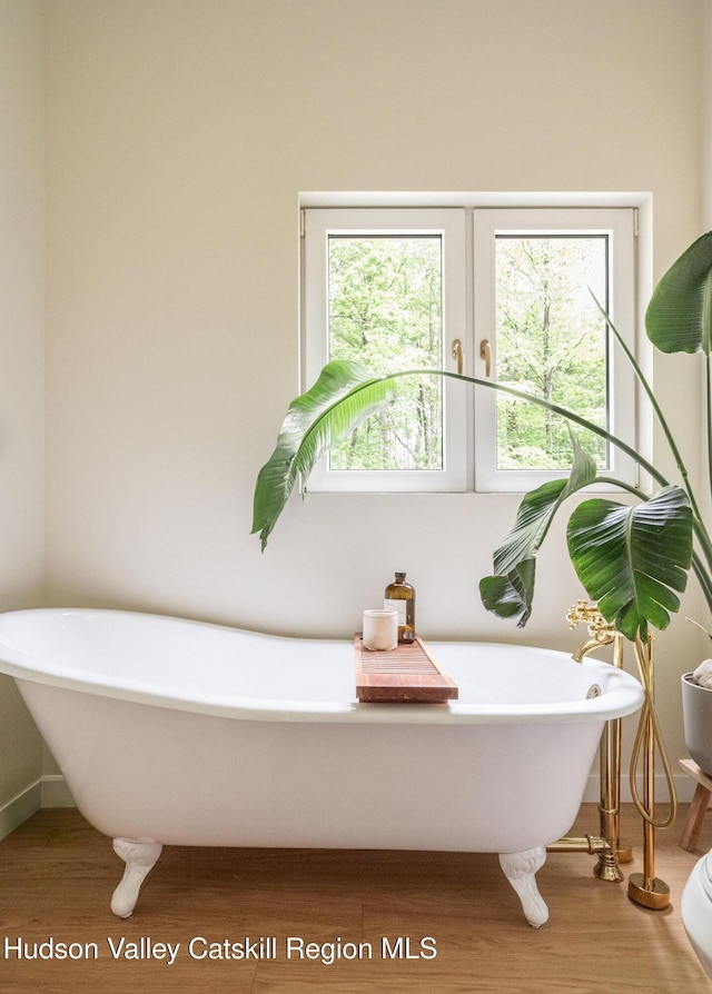 129 Krum Rd, Kerhonkson, NY 12446 - bathroom featuring wood finished floors, a freestanding tub, baseboards, and french doors