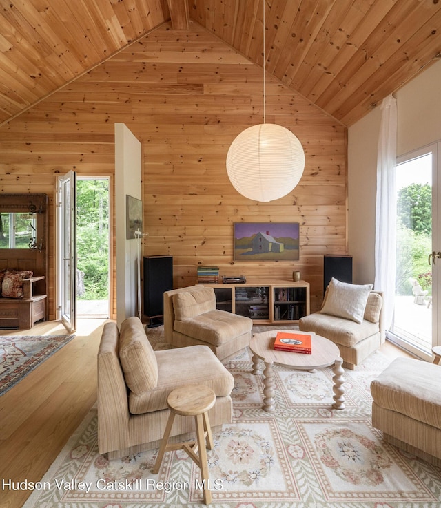 129 Krum Rd, Kerhonkson, NY 12446 - living room featuring wood walls, wooden ceiling with exposed beams, wood finished floors, and high vaulted ceiling