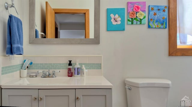 half bath featuring backsplash, toilet, and vanity