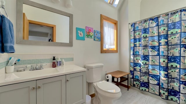 bathroom with tasteful backsplash, toilet, vanity, and a shower with curtain