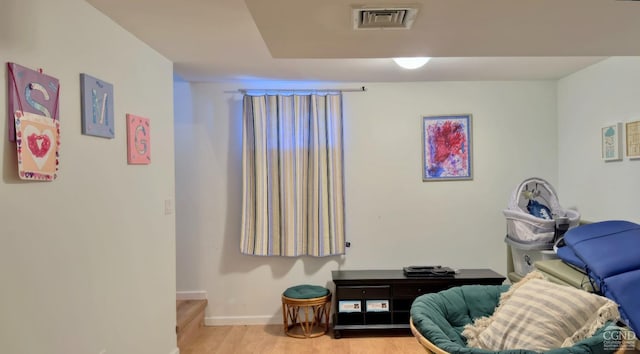 sitting room with baseboards and light wood-type flooring