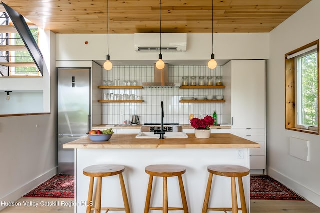 22 Skinner Ln, Catskill, NY 12414 - kitchen with a wall unit AC, open shelves, wood ceiling, stainless steel built in fridge, and wall chimney exhaust hood