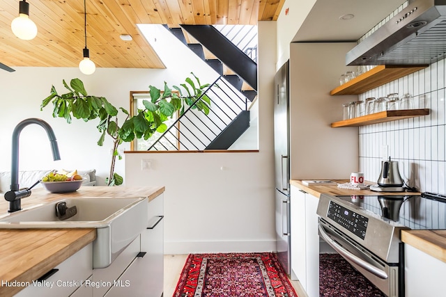 22 Skinner Ln, Catskill, NY 12414 - kitchen featuring stainless steel electric range, under cabinet range hood, butcher block counters, open shelves, and pendant lighting
