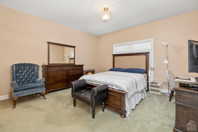 bedroom with light colored carpet and baseboards