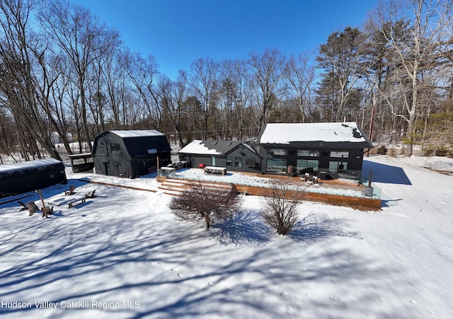 yard covered in snow with an outbuilding and a barn