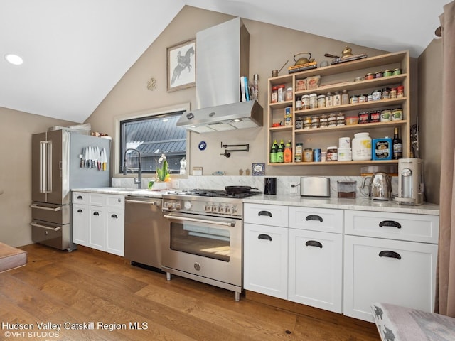 kitchen featuring lofted ceiling, island range hood, white cabinets, and premium appliances