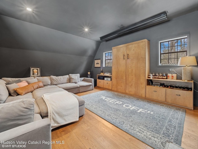 living room featuring light wood-style flooring, vaulted ceiling, and recessed lighting