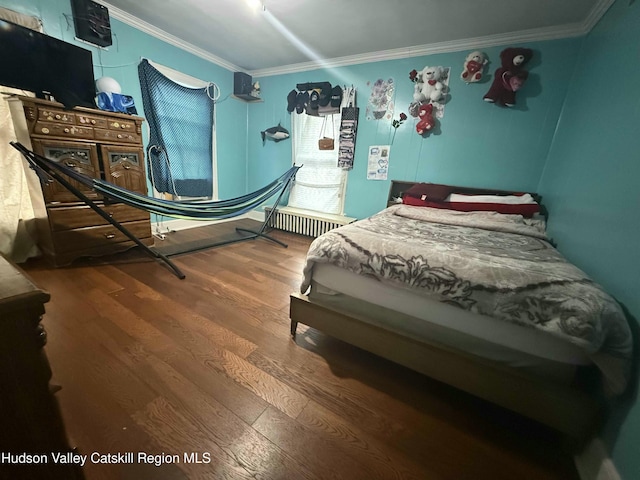 bedroom featuring ornamental molding and wood finished floors