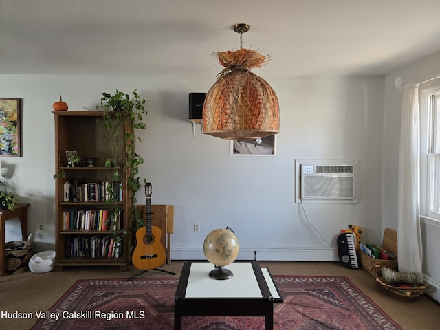 sitting room with carpet, a baseboard heating unit, and a wall unit AC