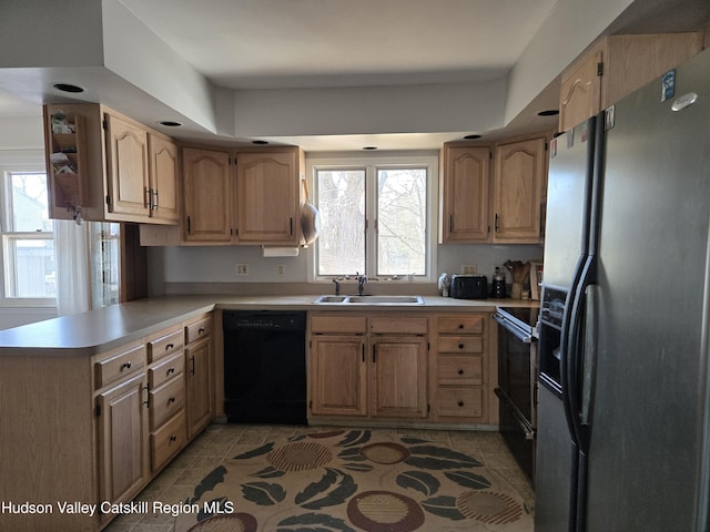 kitchen featuring range with electric stovetop, black dishwasher, sink, stainless steel fridge, and kitchen peninsula