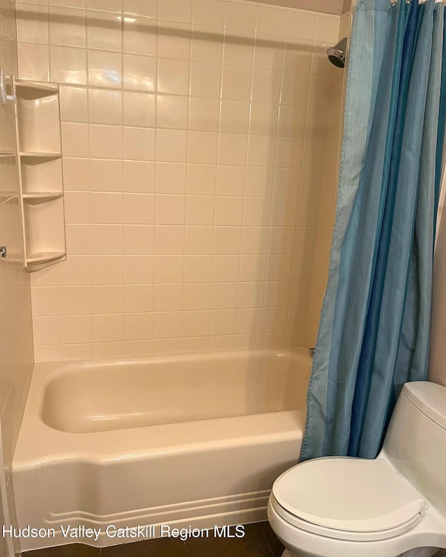 bathroom featuring shower / tub combo with curtain and toilet