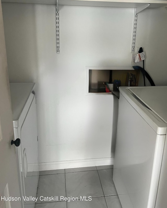 clothes washing area with light tile patterned flooring and washer / dryer