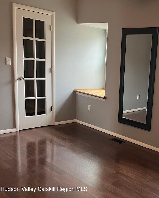 empty room with dark hardwood / wood-style flooring