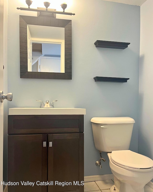 bathroom with vanity, tile patterned flooring, and toilet