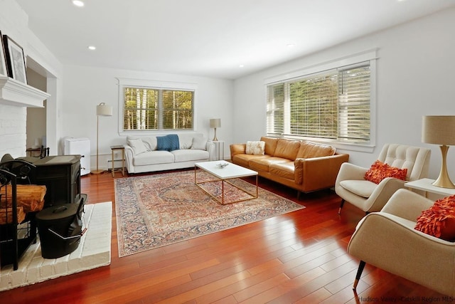 living room with a brick fireplace and hardwood / wood-style flooring