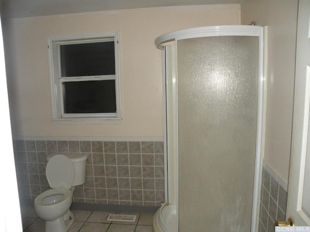 618 Bean River Rd, Pine Plains, NY 12567 - bathroom featuring tile walls, tile patterned floors, toilet, a stall shower, and a wainscoted wall