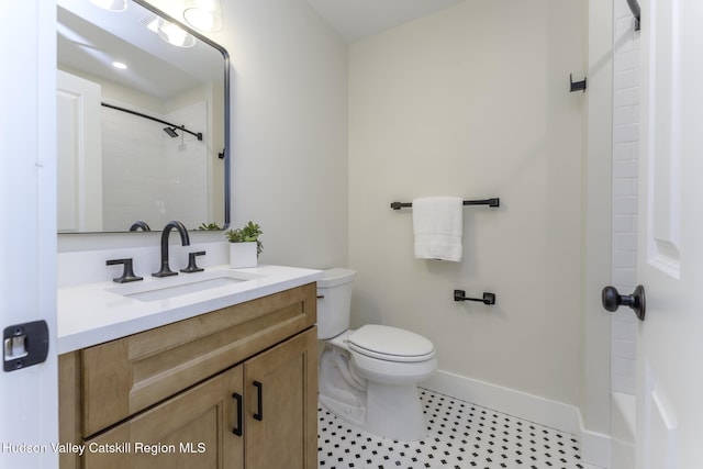 bathroom featuring toilet, vanity, and a shower