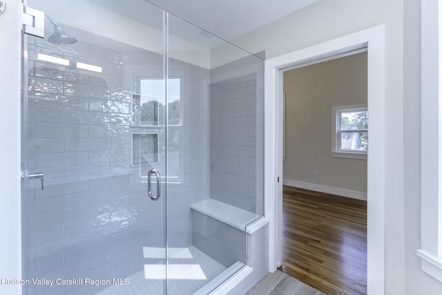 bathroom featuring a shower with shower door and hardwood / wood-style floors