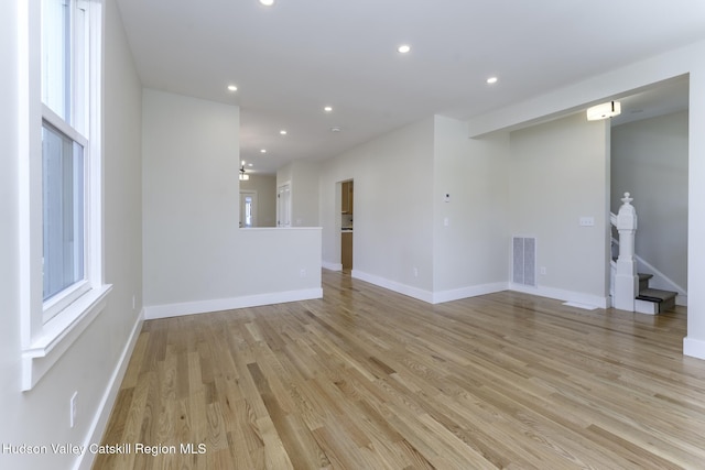 empty room with a chandelier and light hardwood / wood-style floors