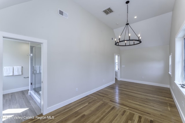 unfurnished dining area featuring high vaulted ceiling, dark hardwood / wood-style flooring, and a notable chandelier