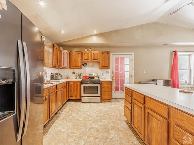 1769 Rte 51, Hannacroix, NY 12087 - kitchen featuring appliances with stainless steel finishes, vaulted ceiling, light countertops, tasteful backsplash, and brown cabinetry