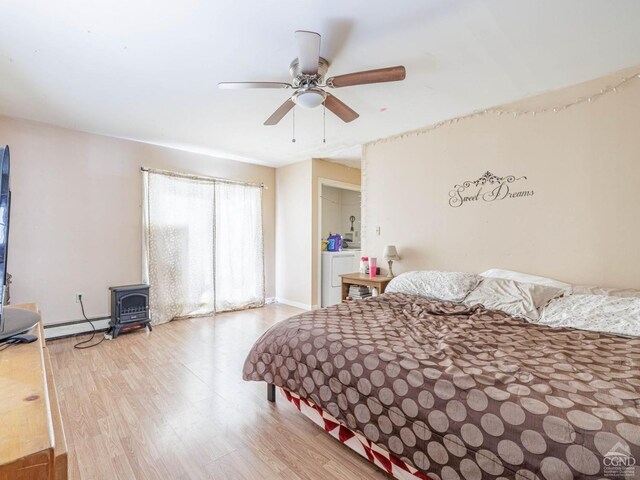 1769 Rte 51, Hannacroix, NY 12087 - bedroom featuring a wood stove, wood finished floors, baseboard heating, baseboards, and ceiling fan