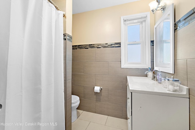 bathroom featuring toilet, vanity, tile walls, and tile patterned floors
