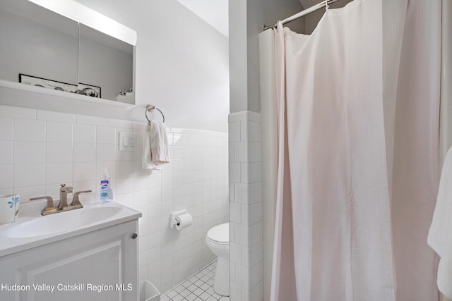 bathroom featuring tile walls, toilet, vanity, a shower with curtain, and tile patterned floors