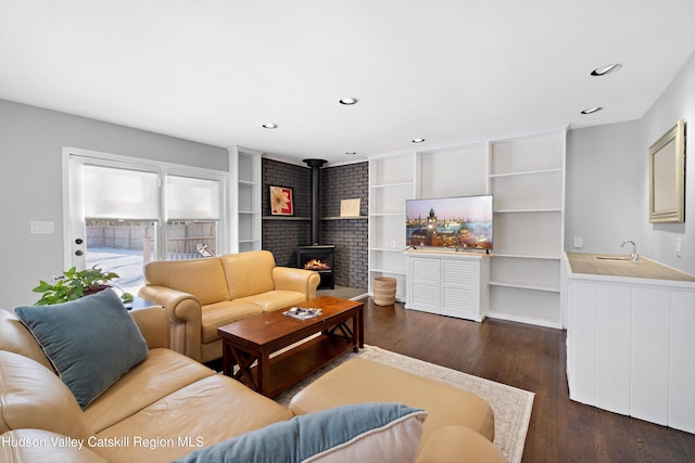 living room featuring a wood stove, dark wood-style floors, and recessed lighting