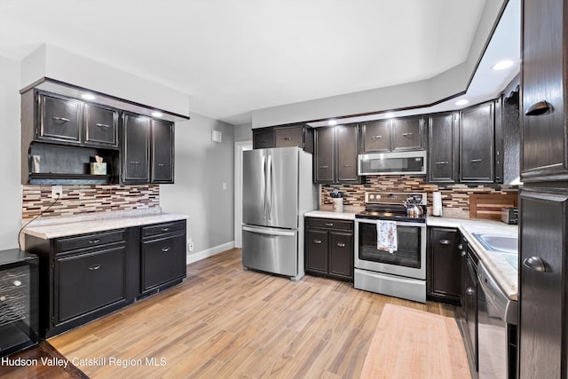 kitchen with beverage cooler, appliances with stainless steel finishes, light countertops, light wood-type flooring, and open shelves