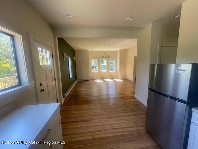 corridor with a chandelier and light hardwood / wood-style floors