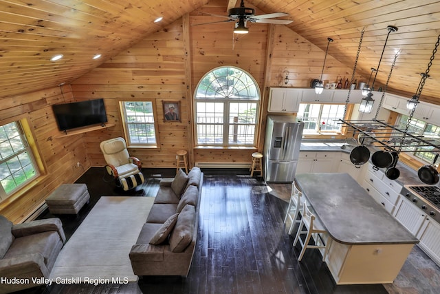 living room with wood walls, dark hardwood / wood-style flooring, high vaulted ceiling, and wooden ceiling