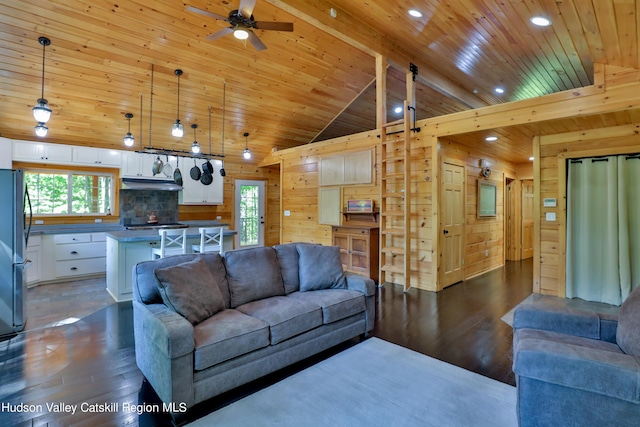 living room featuring a wealth of natural light, dark hardwood / wood-style flooring, and vaulted ceiling